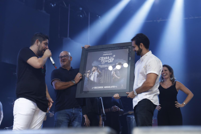 Luiz Garcia, entregando o certificado de "Terra Sem CEP" para Jorge, da dupla Jorge & Mateus, durante sua passagem pela Som Livre.