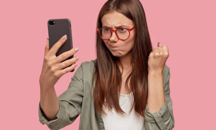 mulher com celular na mão com raiva